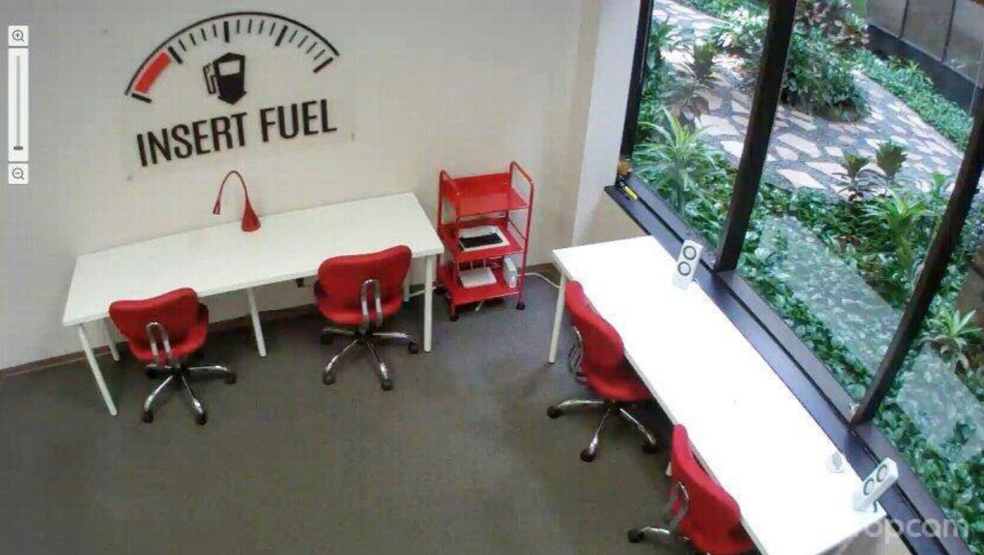 The first Insert Fuel office in Houston with red chairs, white desks and the logo on the wall