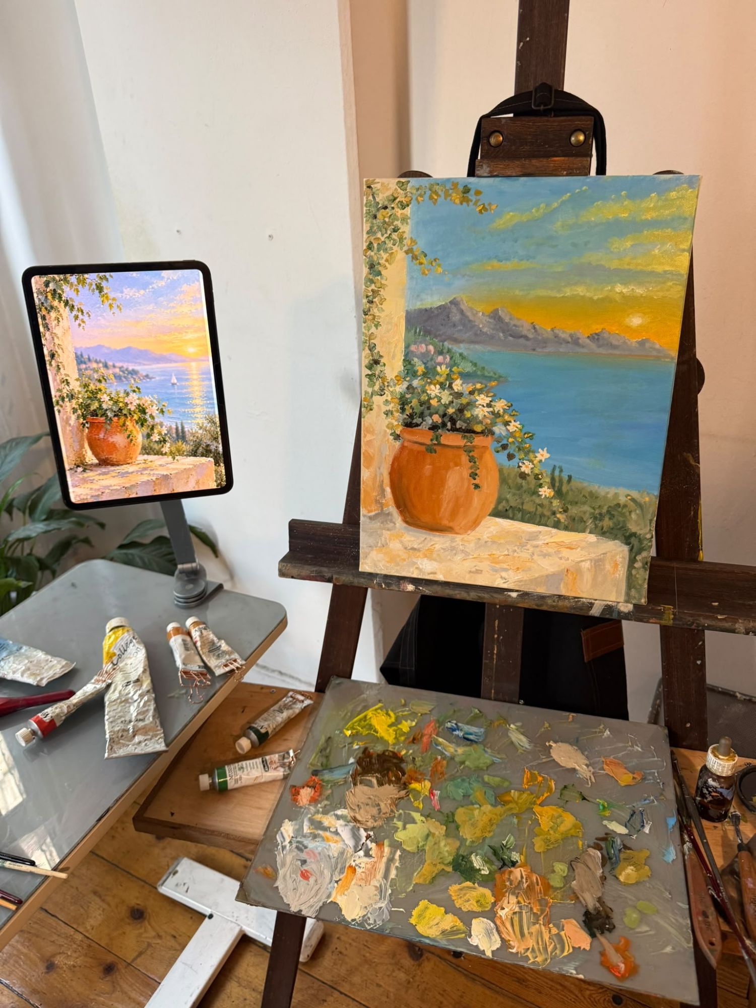 The easel, palette and the iPad reference beside the finished canvas